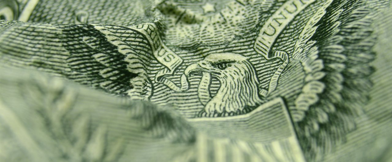 Close-up of eagle on a wrinkled one dollar bill.