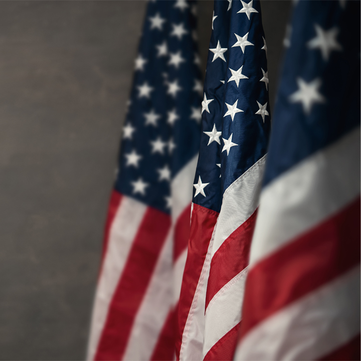 American flags over gray wall