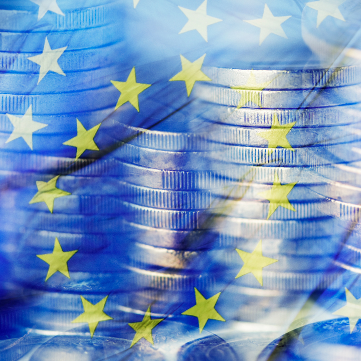 Stacks of coins and the European Union flag with layering effect