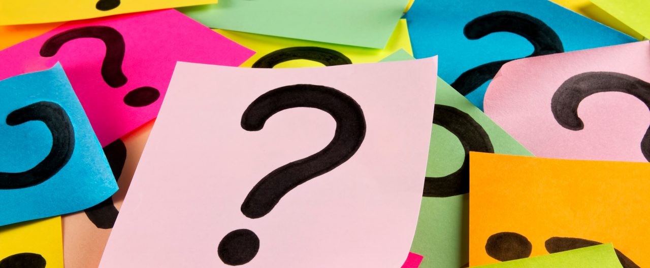 Pile of colorful sticky notes with hand drawn question marks. It is a seamless background which was created with adhesive note papers.