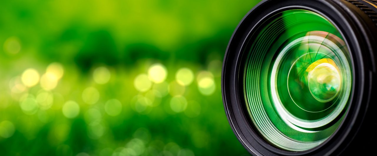 Camera lens on blurry green background