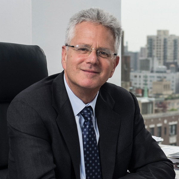 Dr. Jeffrey Borenstein sittin in his office with view of a city through the window