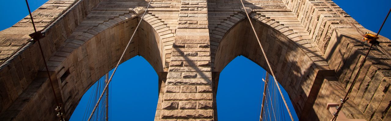 Upward View of the Brooklyn Bridge Against Bright Blue Sky