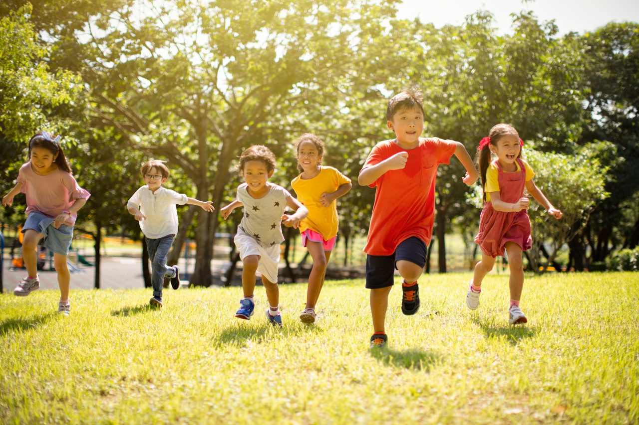 group of school children laughing and running on a sunny day